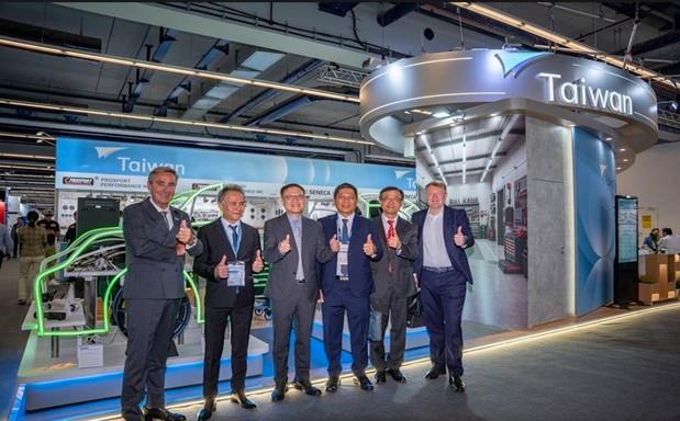 Distinguished guests and speakers pose for a group photo in front of the concept car display at the flagship Taiwan Pavilion following the opening cer
