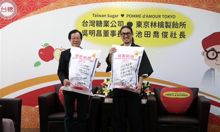 台糖董事長吳明昌(左)與東京林檎製飴所社長池田喬俊抱著特製台糖細砂抱枕合影。